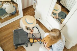 Woman and child packing a suitcase.